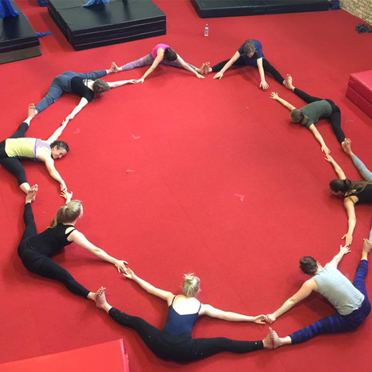 Circle of students stretching on the floor
